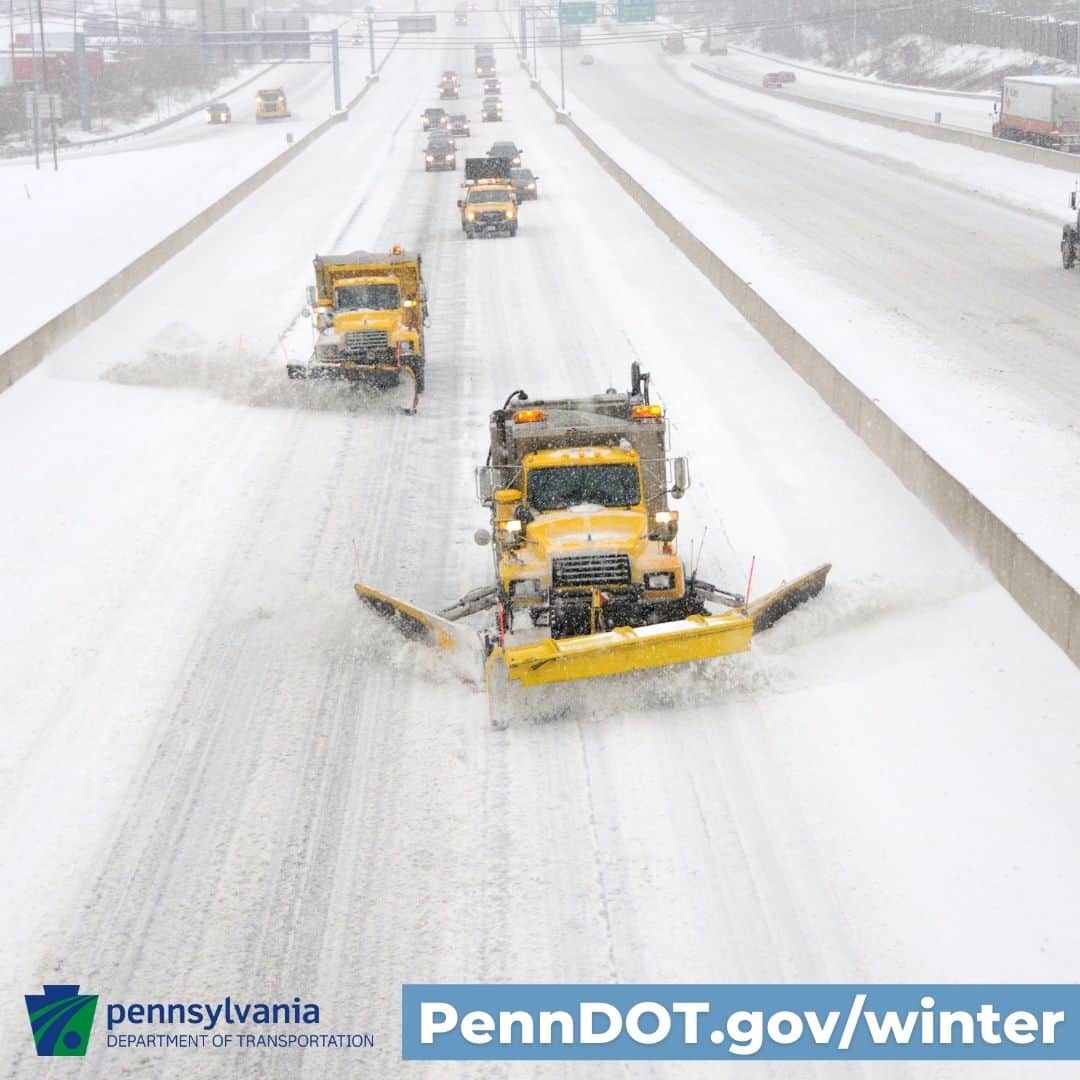 PennDOT plows clear a snow-coated highway.