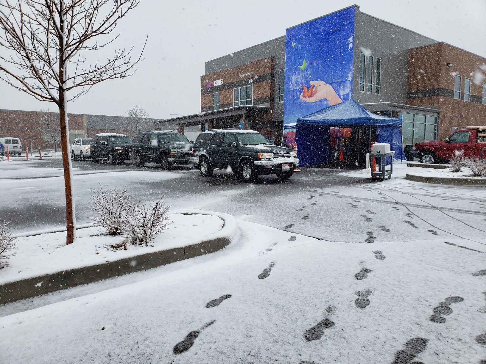 Drive-thru food distribution on a snowy day.